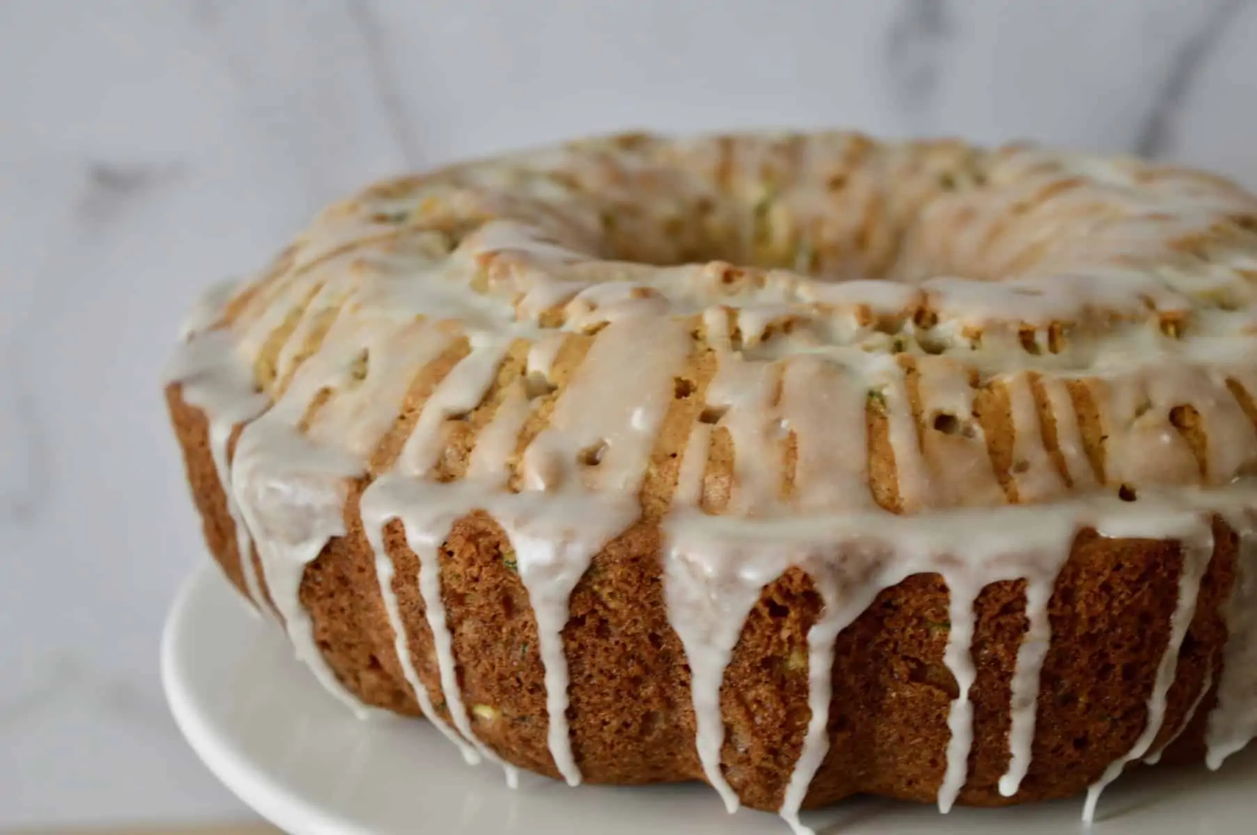 Pineapple Zucchini Cake on a white pedestal.