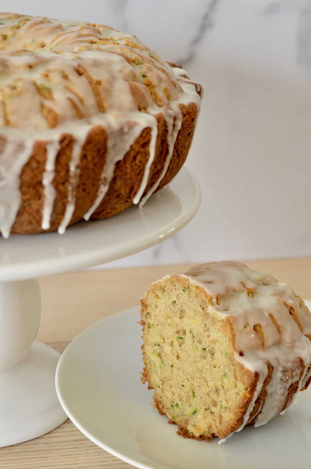 cake on a pedestal with a slice next to it. 