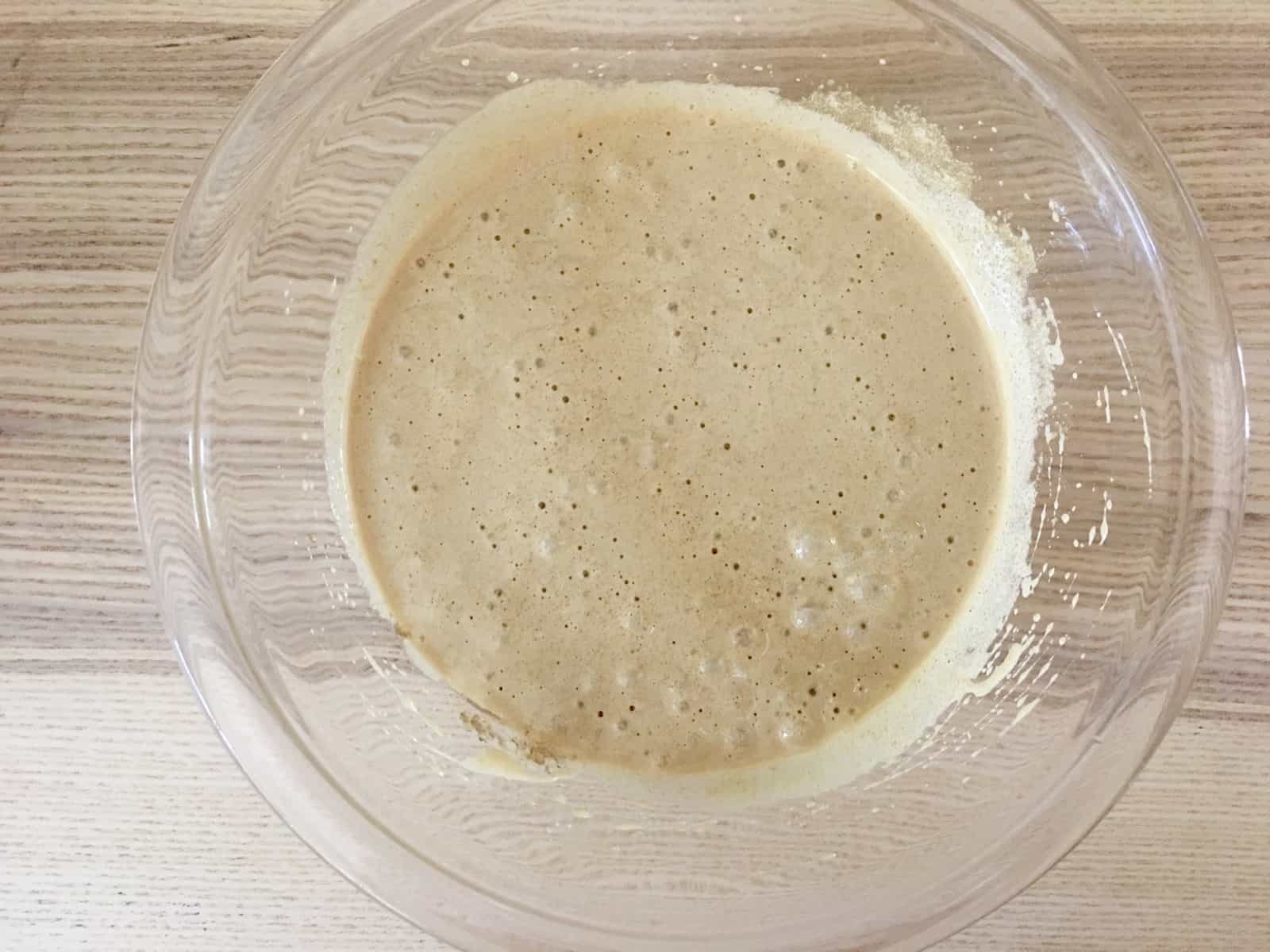 Eggs and brown sugar whisked together in a glass bowl. 