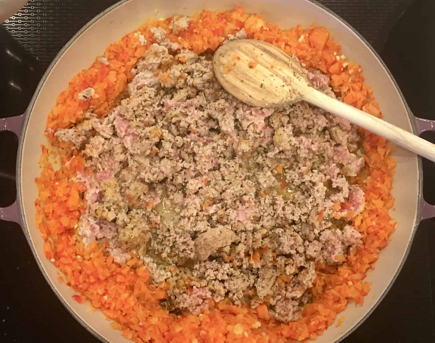 ground turkey cooking in the middle of the braiser pan with veggies on the side. 