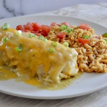 Green Chili Chicken Burritos on a white plate with mexican rice.