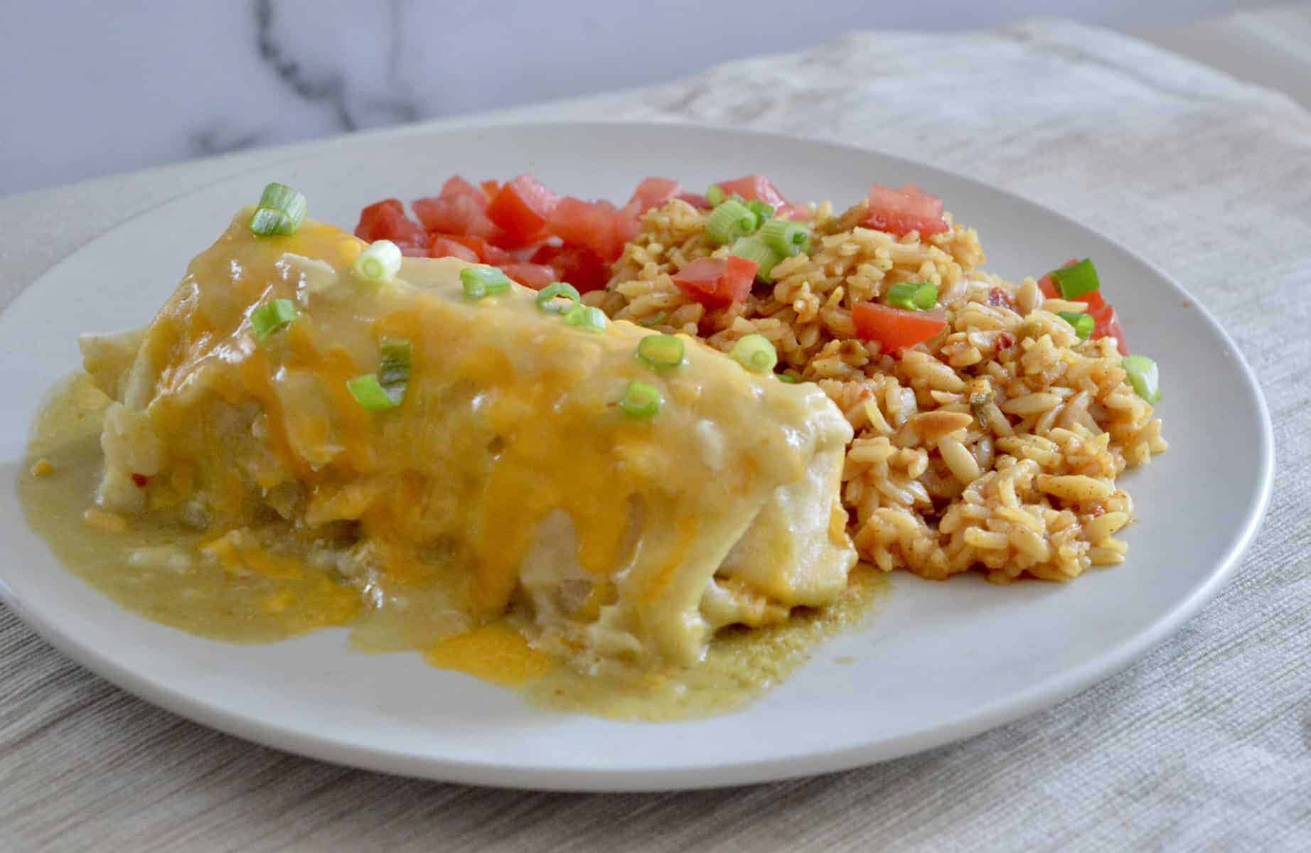 Green Chili Chicken Burritos on a white plate with mexican rice.