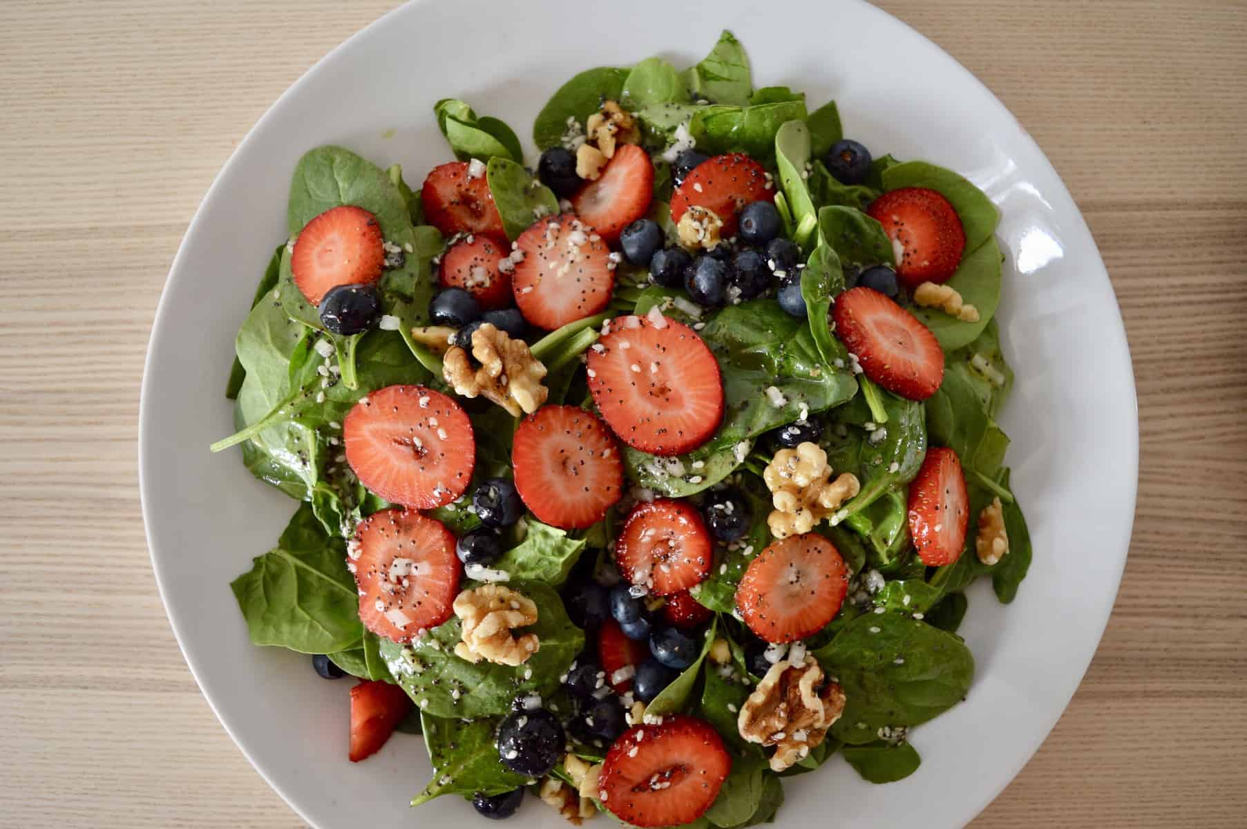 aerial view of strawberry blueberry spinach salad. 