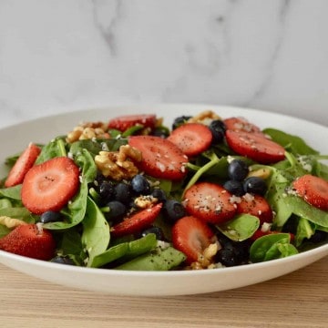 salad in a white porcelain bowl on a wood countertop.