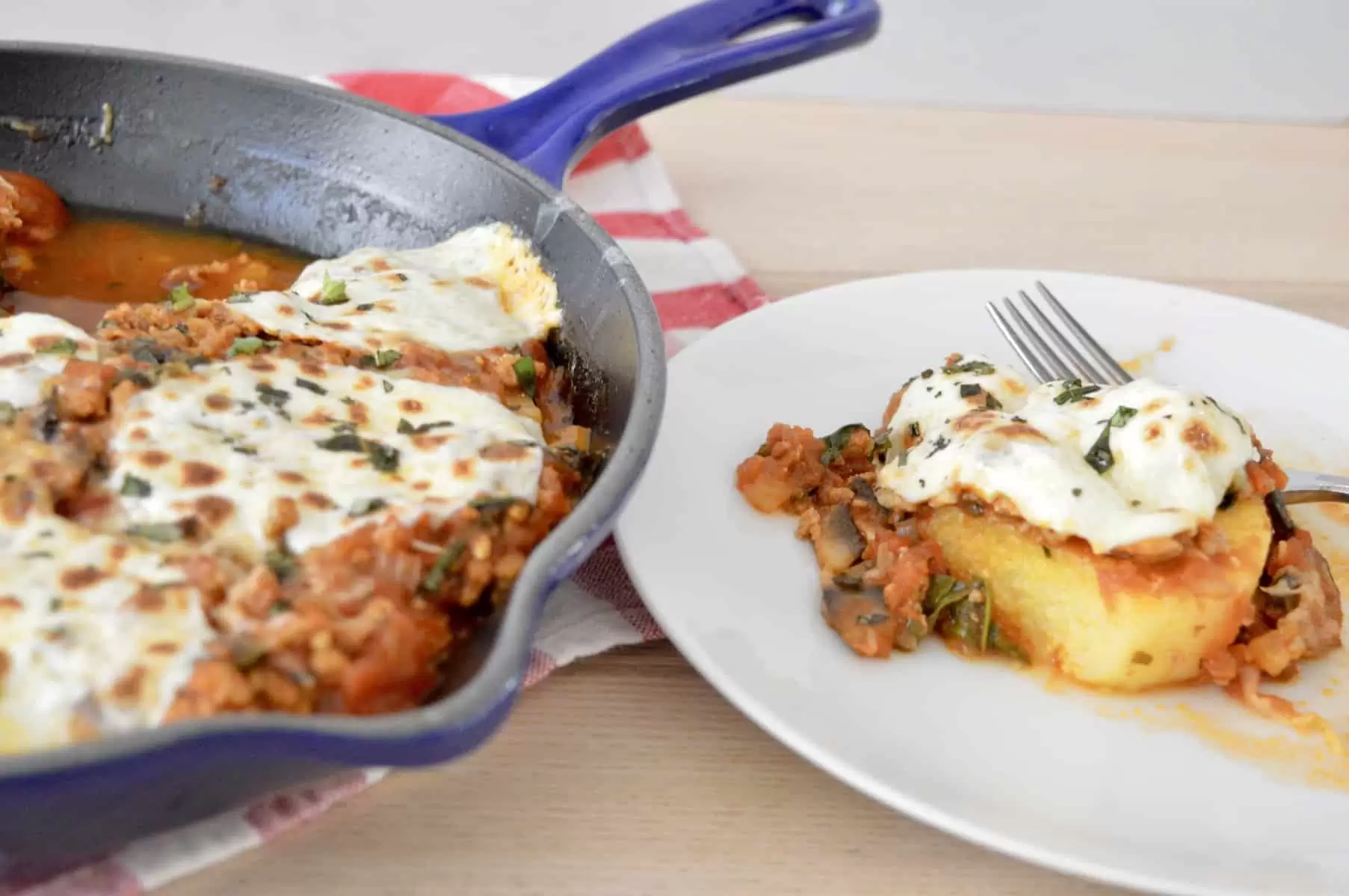 Italian polenta skillet with slice of polenta on a white plate. 