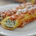 Close up of spinach turkey manicotti on a white plate.