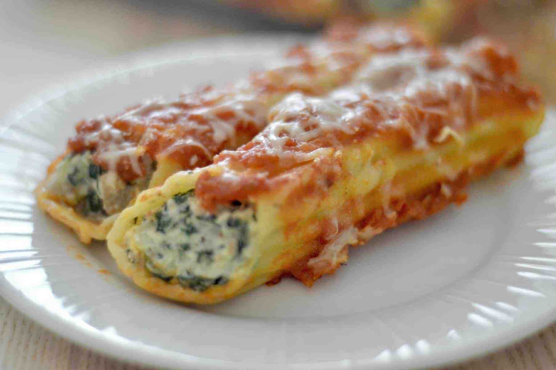 Close up of spinach turkey manicotti on a white plate.