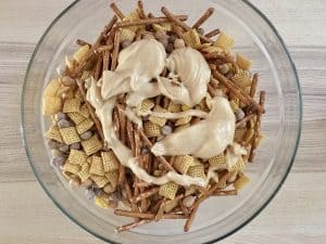 peanut butter white chocolate sauce drizzled over top of the peanut butter muddy buddies.