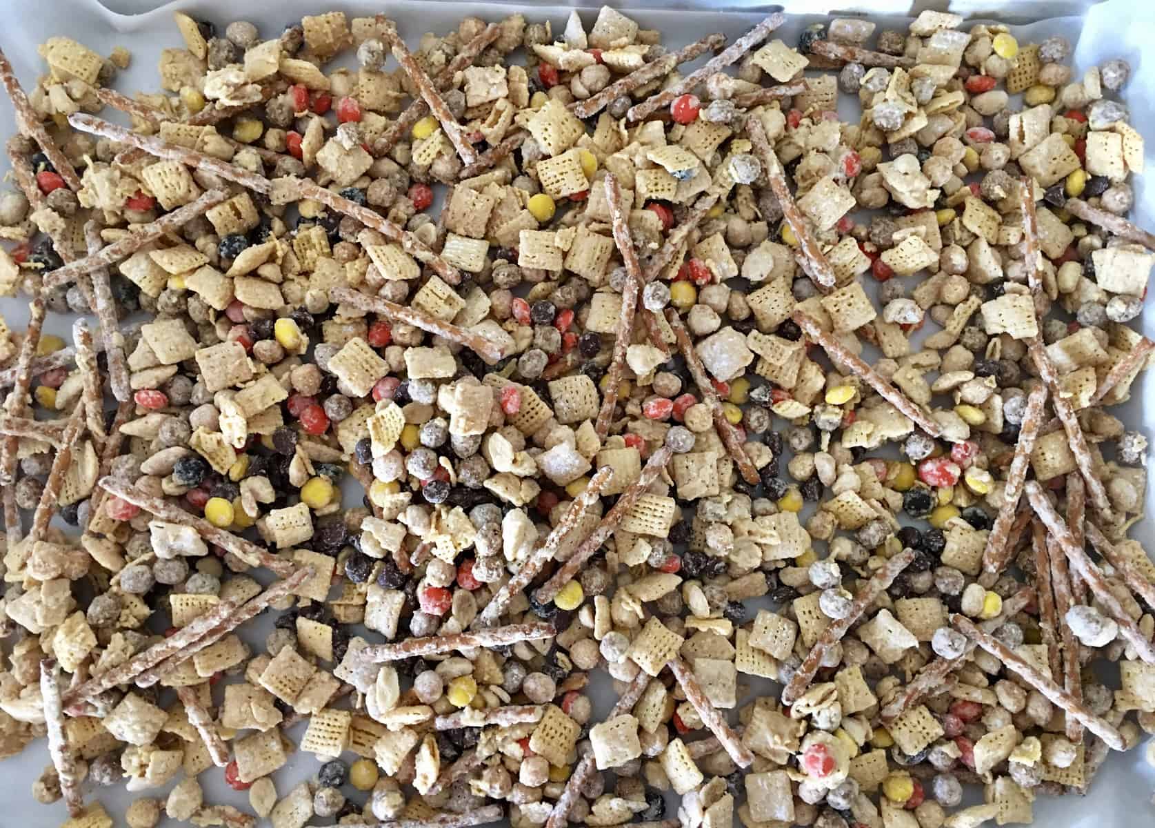 Muddy Buddie peanut butter snack mix drying on a parchment sheet. 