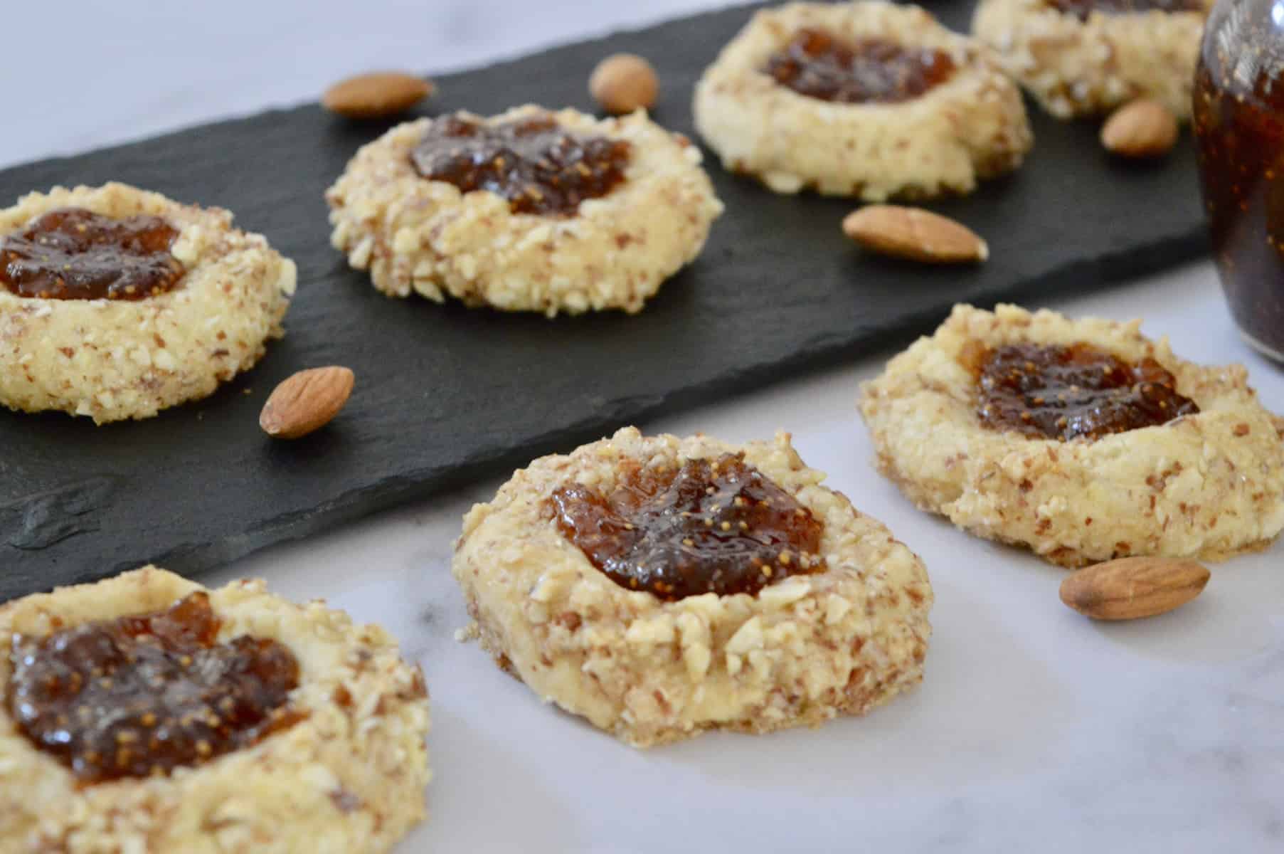 Italian Thumbprint Cookies on black slate on a white countertop. 