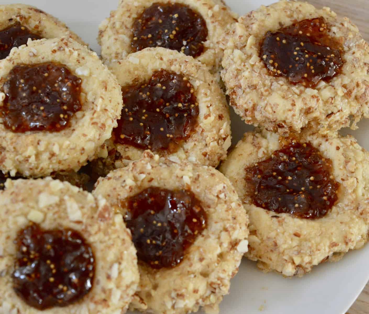 overhead view of Italian thumbprint cookies with fig spread and almonds. 