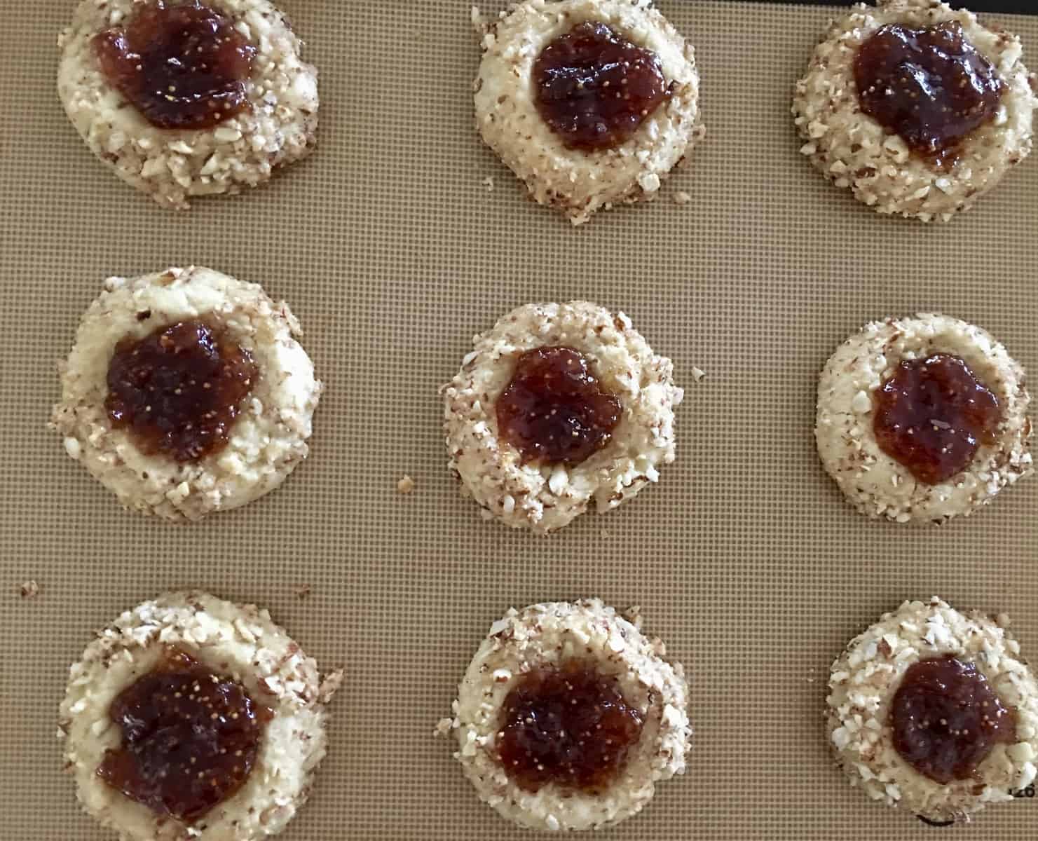 jam filled cookies on baking sheet. 