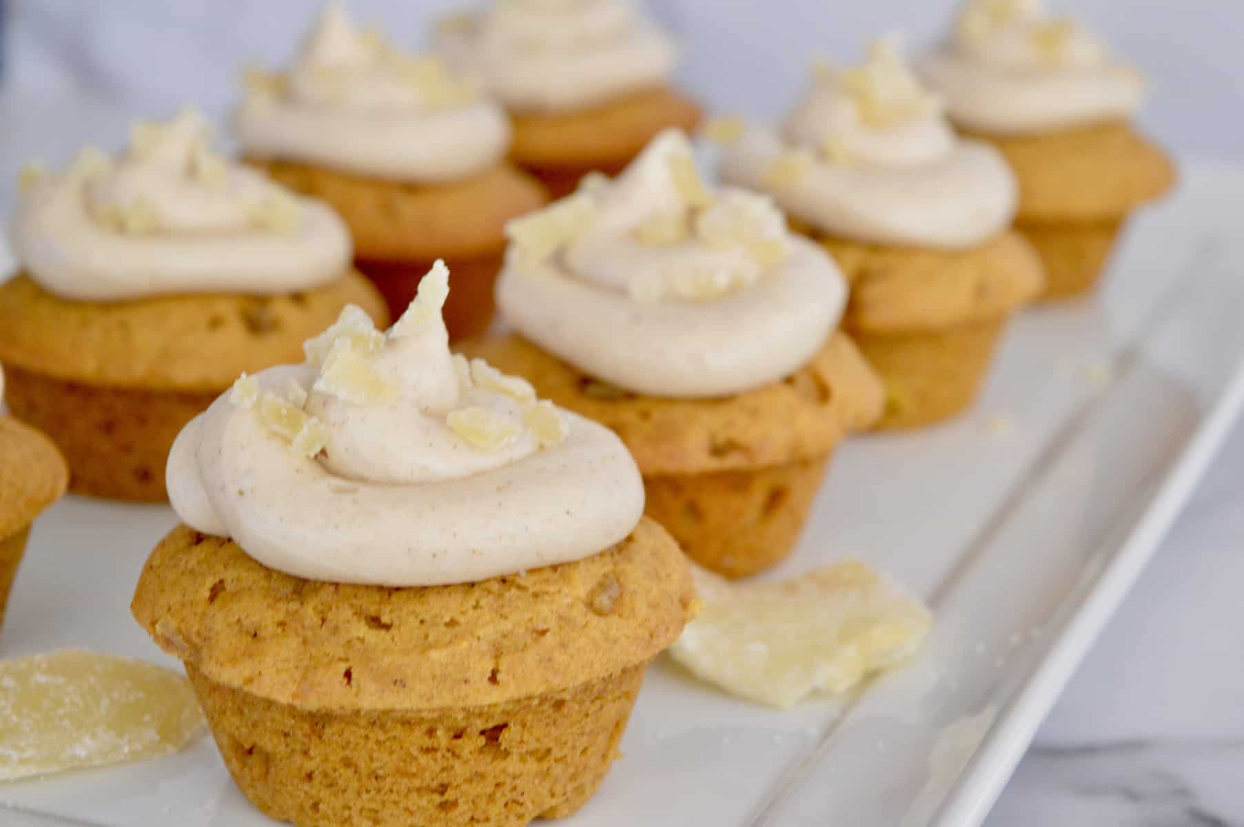 pumpkin ginger cupcakes on a white serving platter.