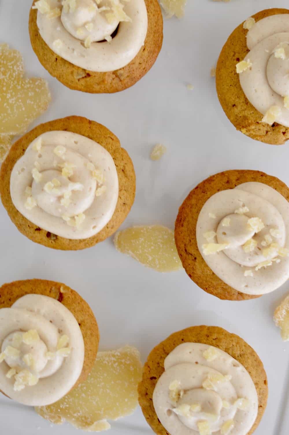 overhead photo of pumpkin ginger cupcakes with diced ginger on top. 