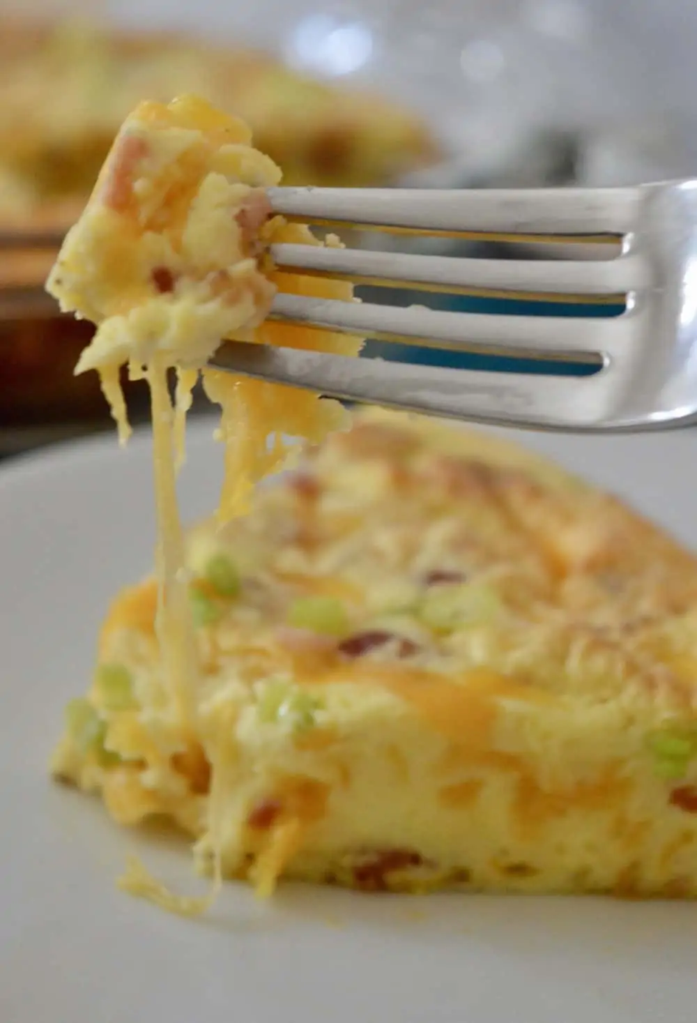 fork full of eggs and cheese from the bacon cheddar crustless quiche. 
