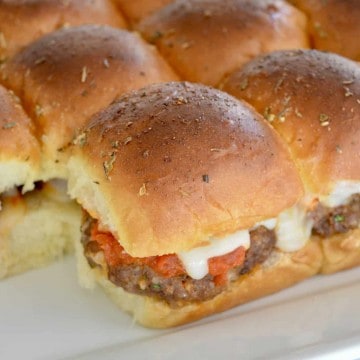 mini baked meatball sandwiches on a white serving platter.