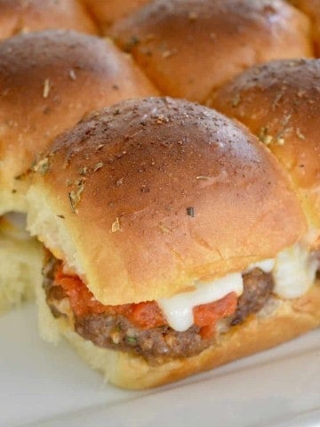 mini baked meatball sandwiches on a white serving platter.
