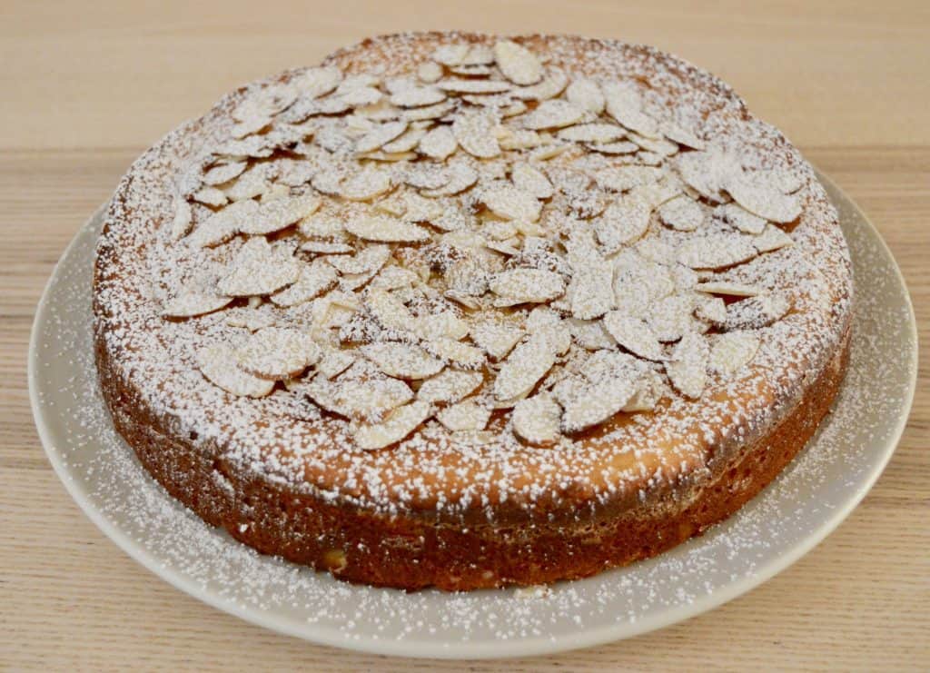 powdered sugar and almonds on the top of the  Italian Almond Ricotta Cake. 