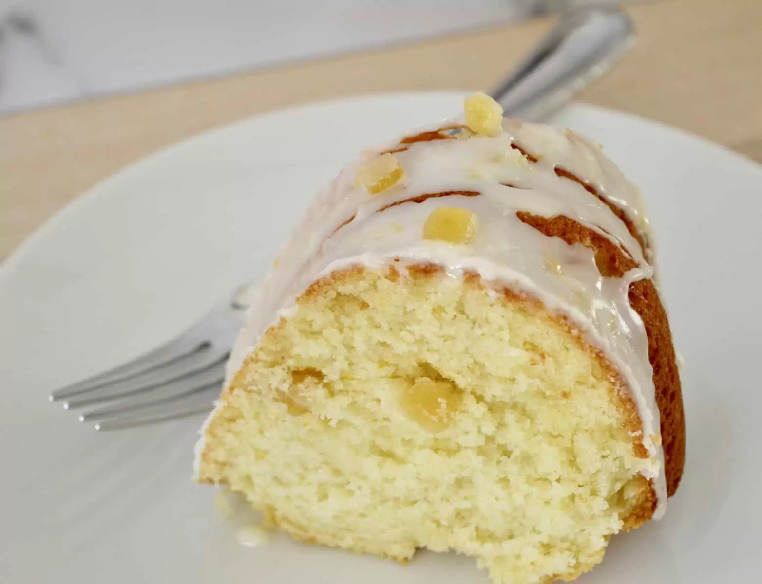 Slice of breakfast cake on a white plate with a fork next to it. 