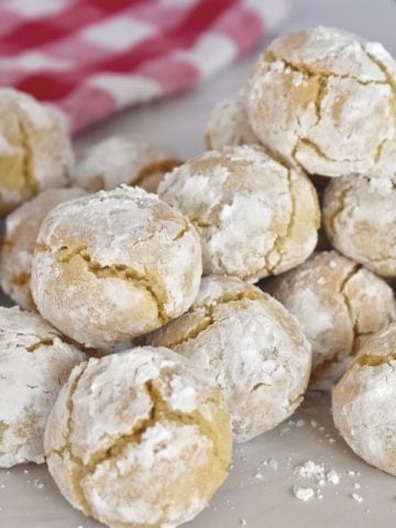Soft Amaretti cookies piled high on a countertop.