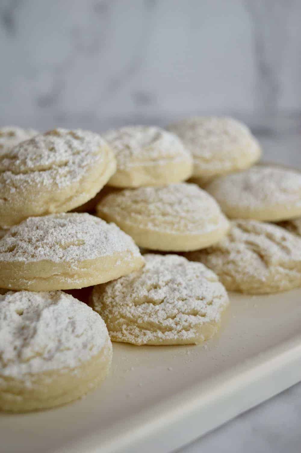Greek butter cookies stacked on a white plate. 
