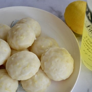 Limoncello Ricotta Cookies on a plate with Limoncello liqueur.