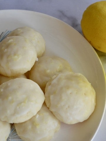Limoncello Ricotta Cookies on a plate with Limoncello liqueur.
