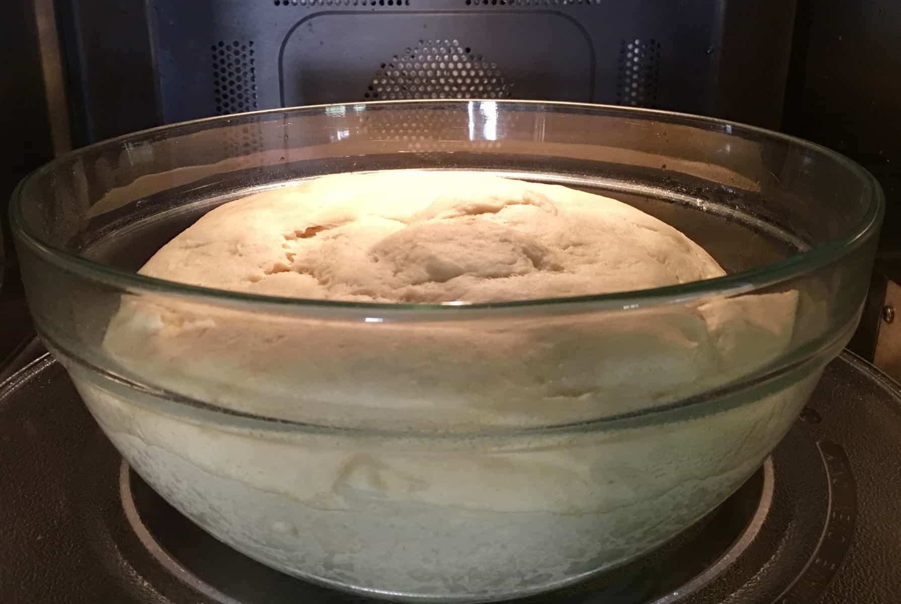 dough rising in greased bowl in microwave. 