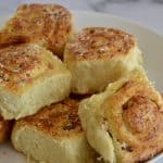 pinwheel bread rolls on a white serving platter.