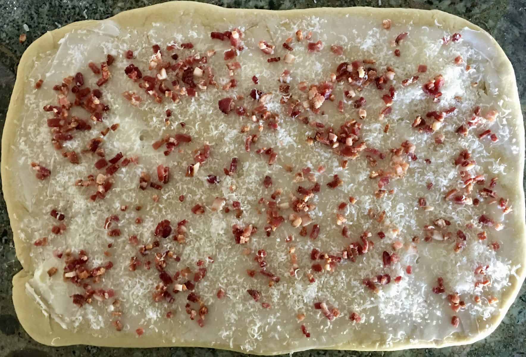 bacon and parmesan sprinkled on the dough. 