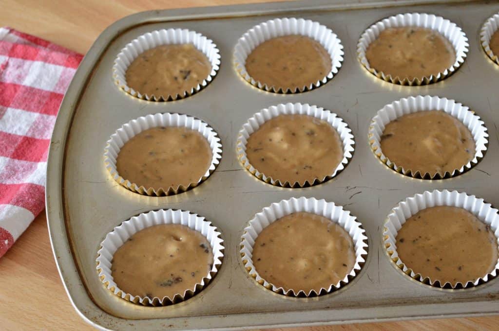 La masa se vierte en los revestimientos en una lata para muffins. 