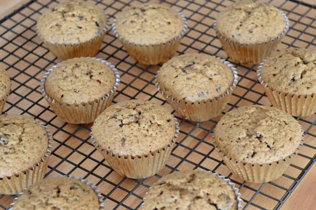 muffins in gouden voeringen die koelen op een draadkoelrek. 