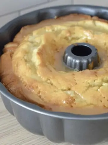 Amaretto Pound Cake in a pan with Amaretto butter glazed poured over it.