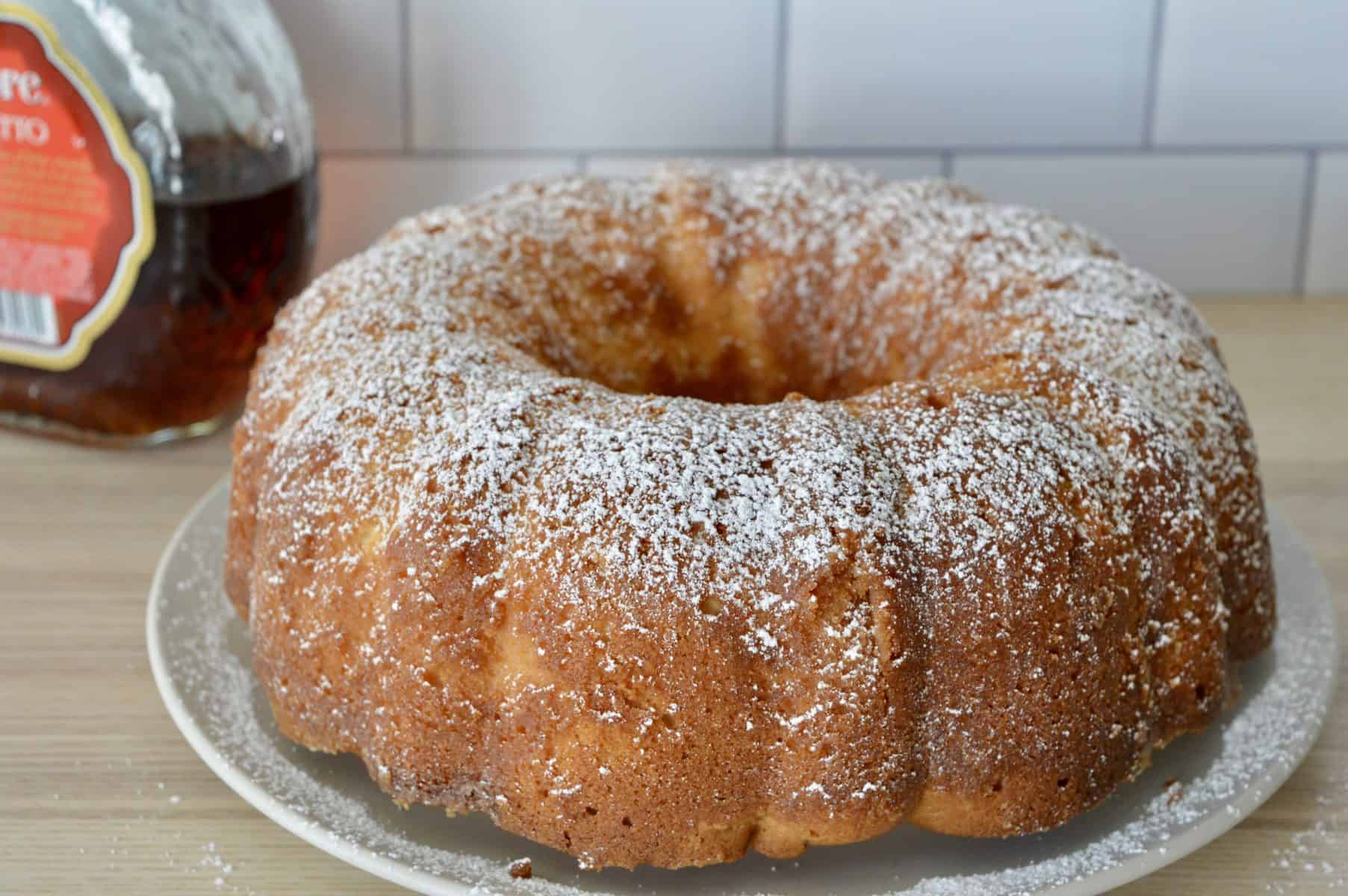 Bundt on plate with powdered sugar sprinkled on top.