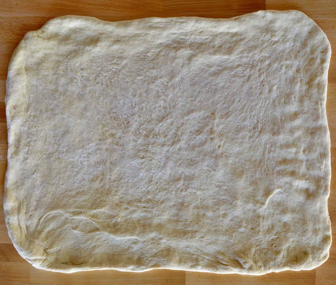 Stromboli dough rolled out into large rectangle. 