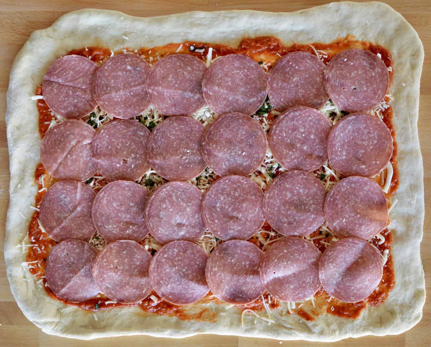 Salami laid over top of the dough for the Italian Stromboli Recipe. 