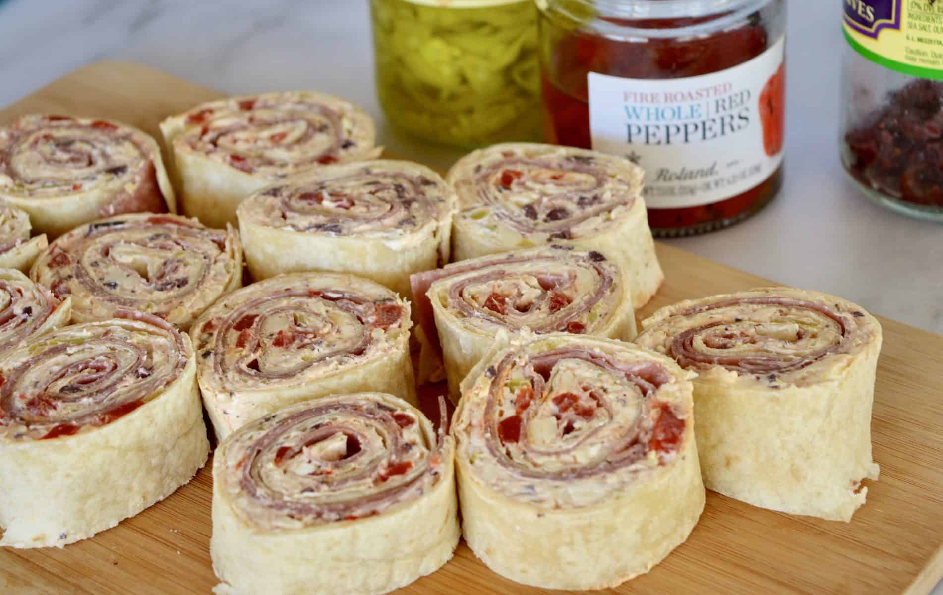 Italian Antipasto Pinwheels on a wood cutting board.