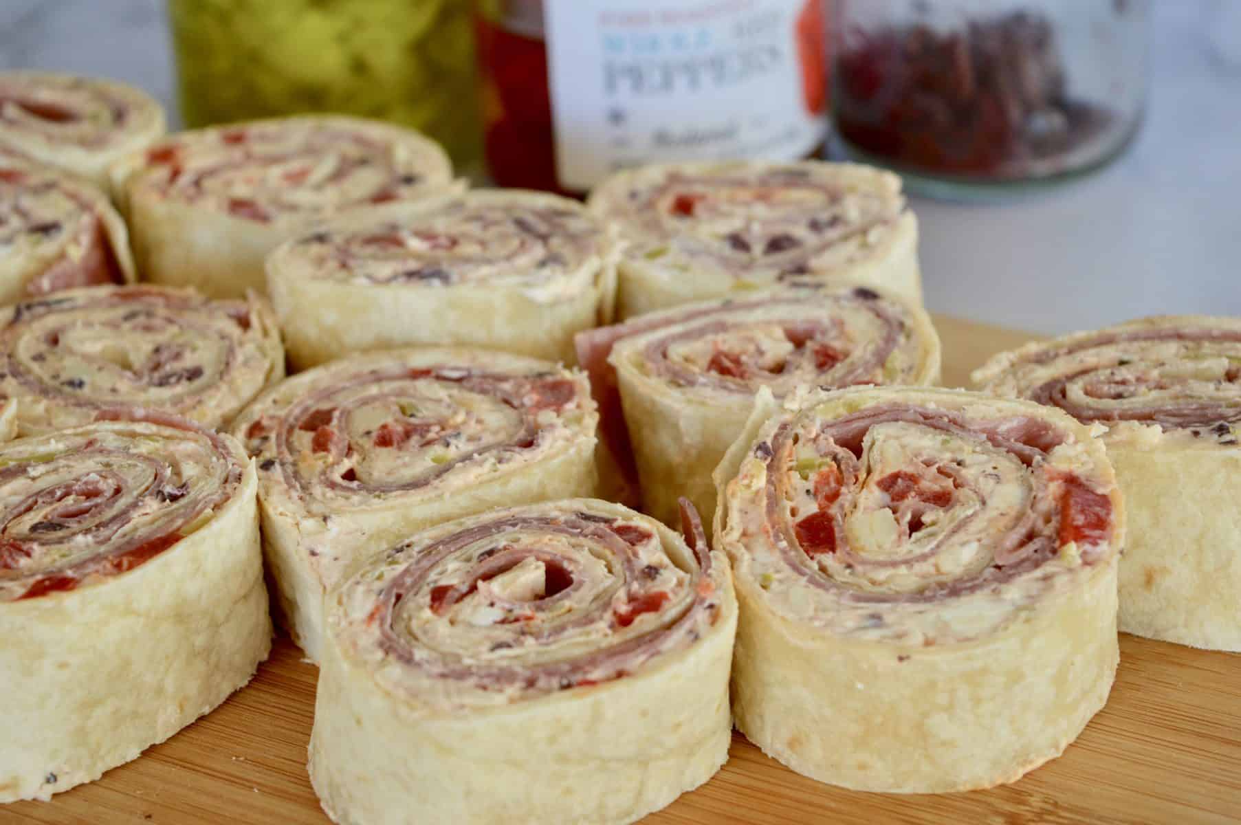 Italian roll ups on a wooden cutting board.