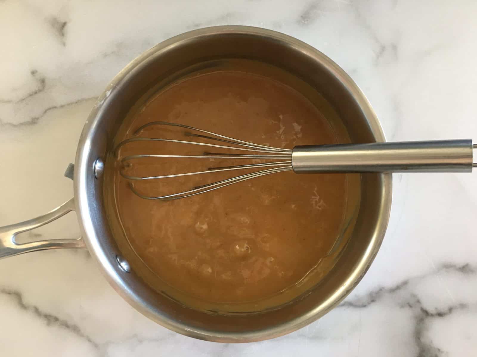 Caramel Sauce in a saucepan with a whisk. 