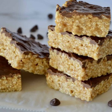 Caramel Peanut Butter Krispies staked on a white countertop.