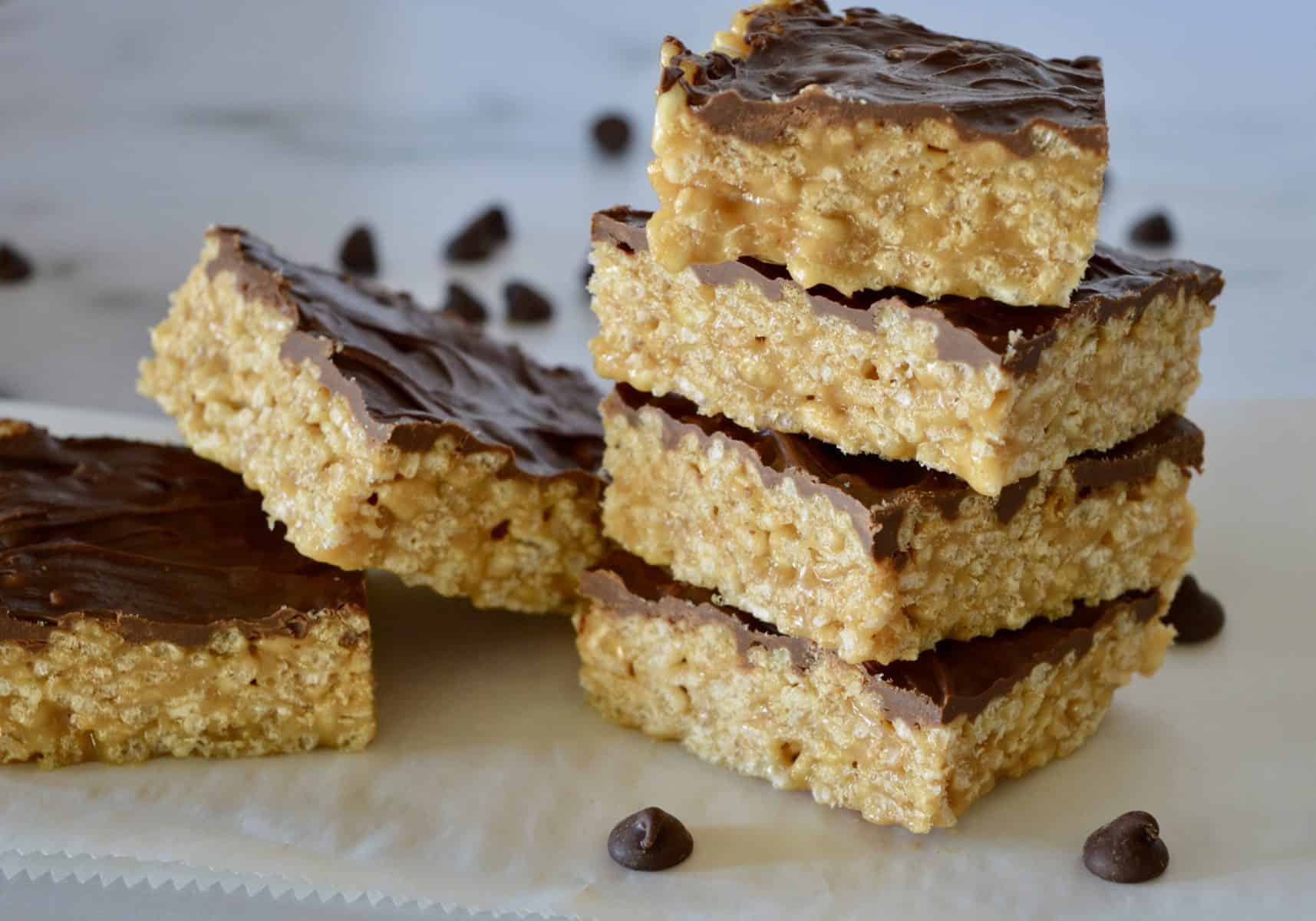 Caramel Peanut Butter Krispies staked on a white countertop.