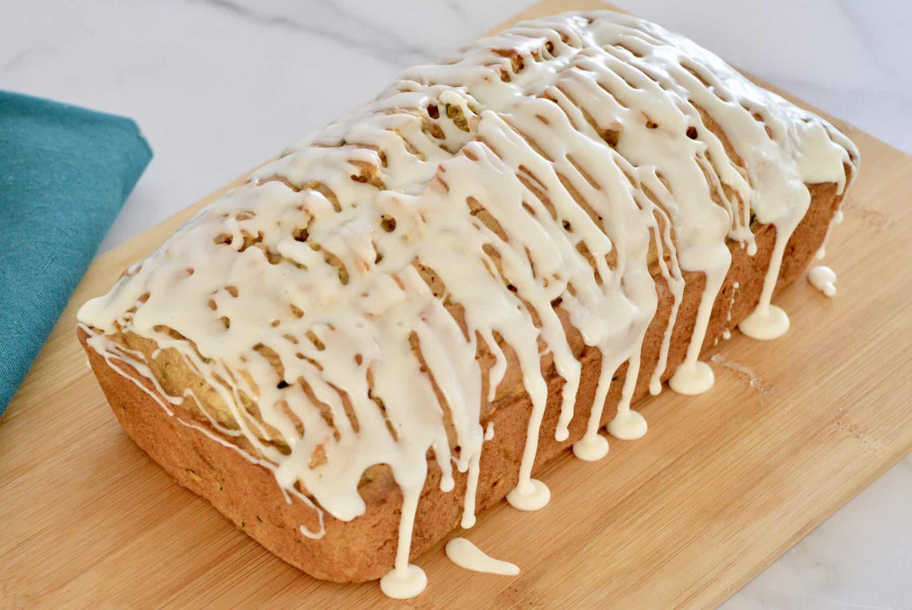 Glazed Zucchini Apple Bread on a wood cutting board. 