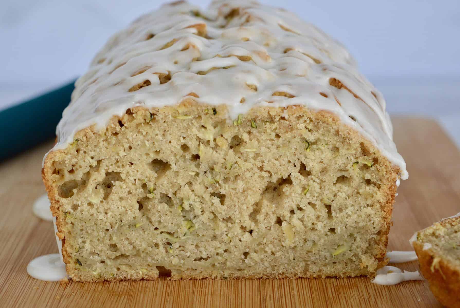 Cut view of zucchini apple bread on a wood cutting board. 