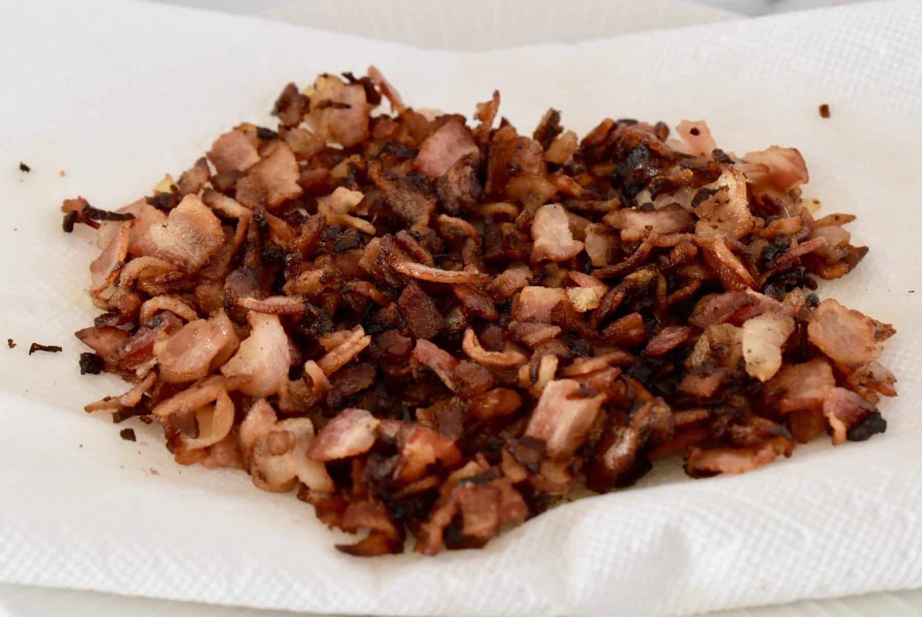Cooked bacon and onion draining on a paper towel.