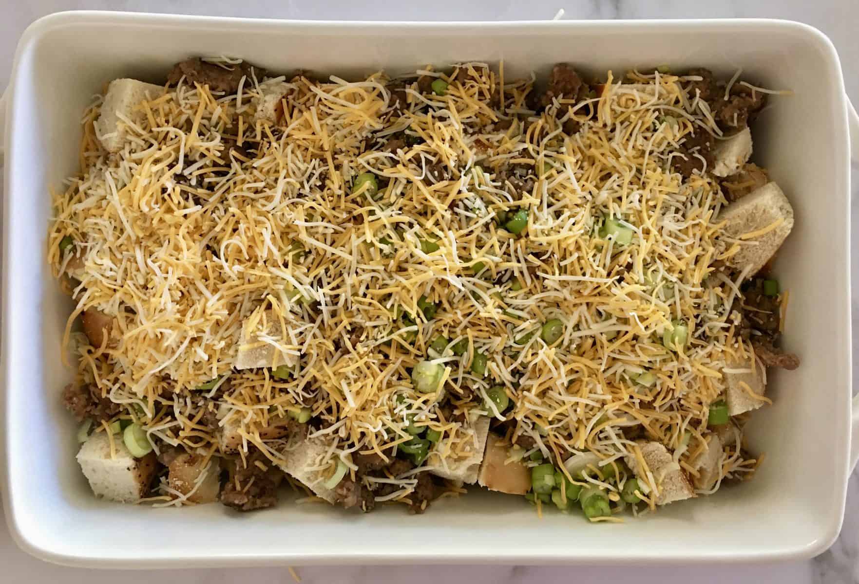 Breakfast Casserole filled with bread, meat, green onions, and cheddar cheese.