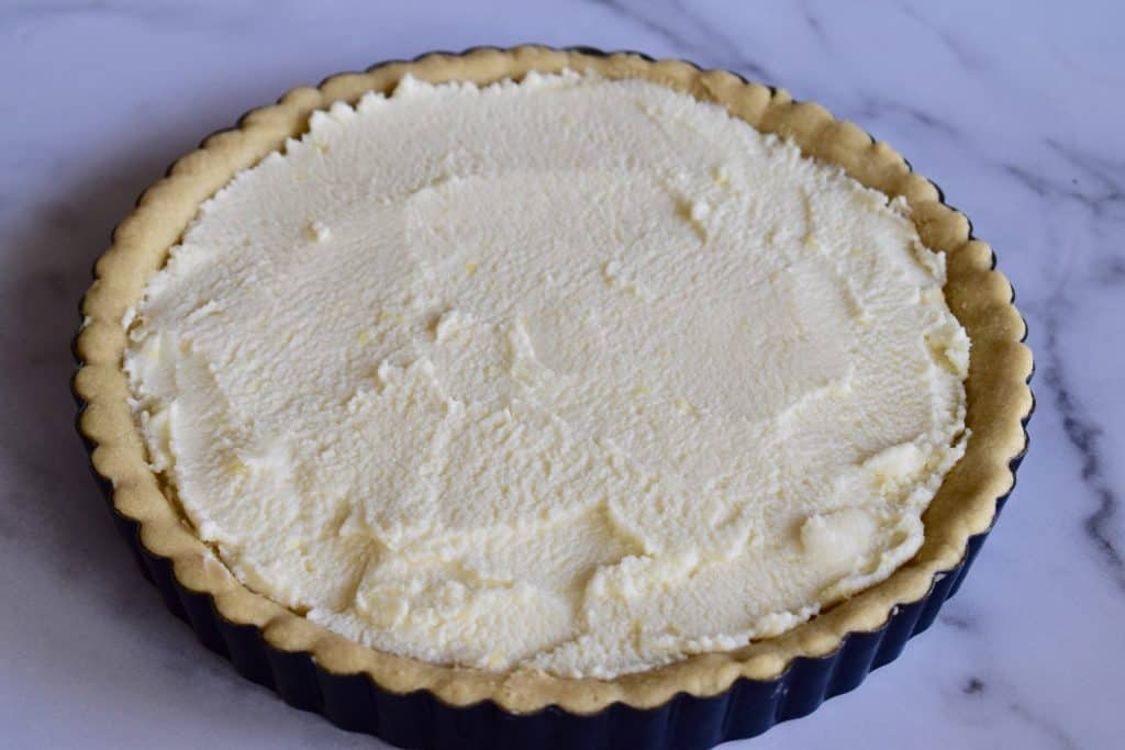  Recheio de mascarpone alisado em cima da crosta de tarte de azeite resfriada. 