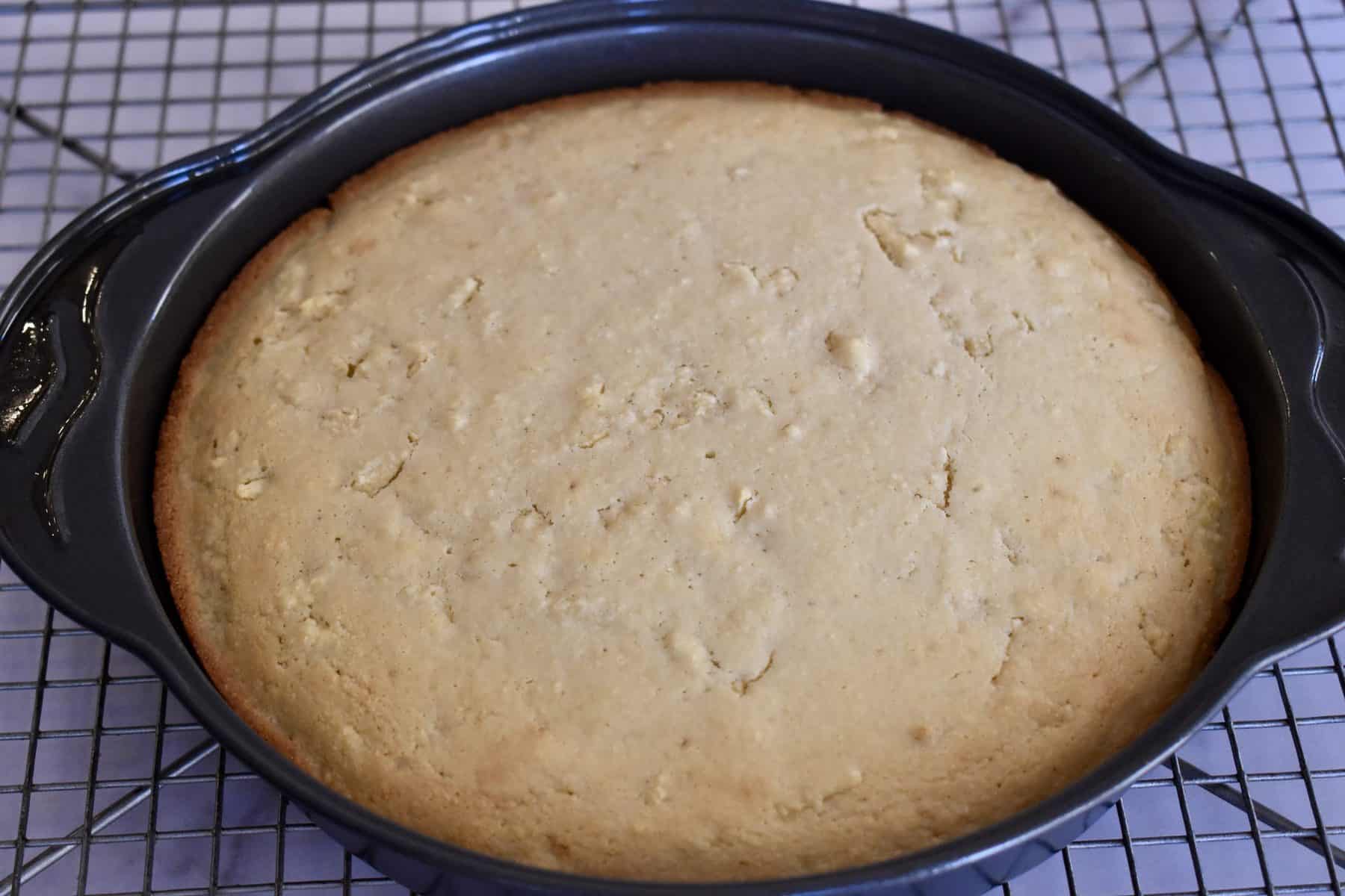 almond flour apple cake cooling in a cake pan. 