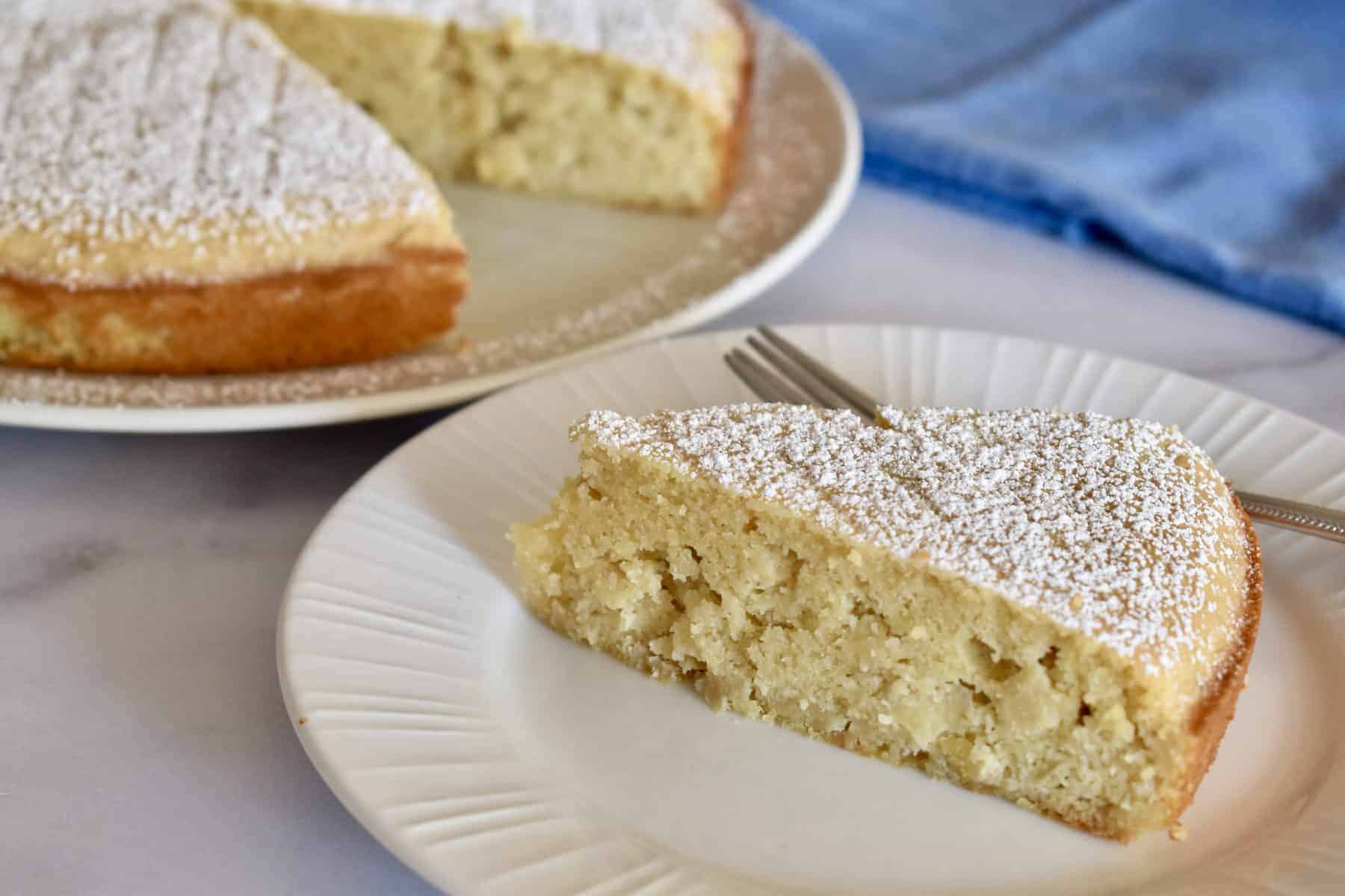 Almond Flour Apple Cake on a white plate with a blue napkin in the background. 