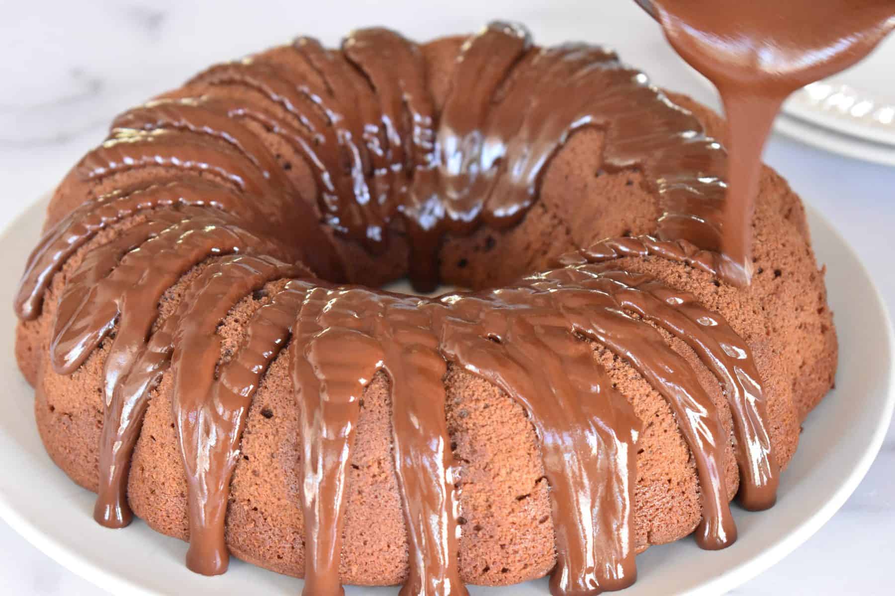 Chocolate being drizzled over the chocolate ricotta bundt cake. 