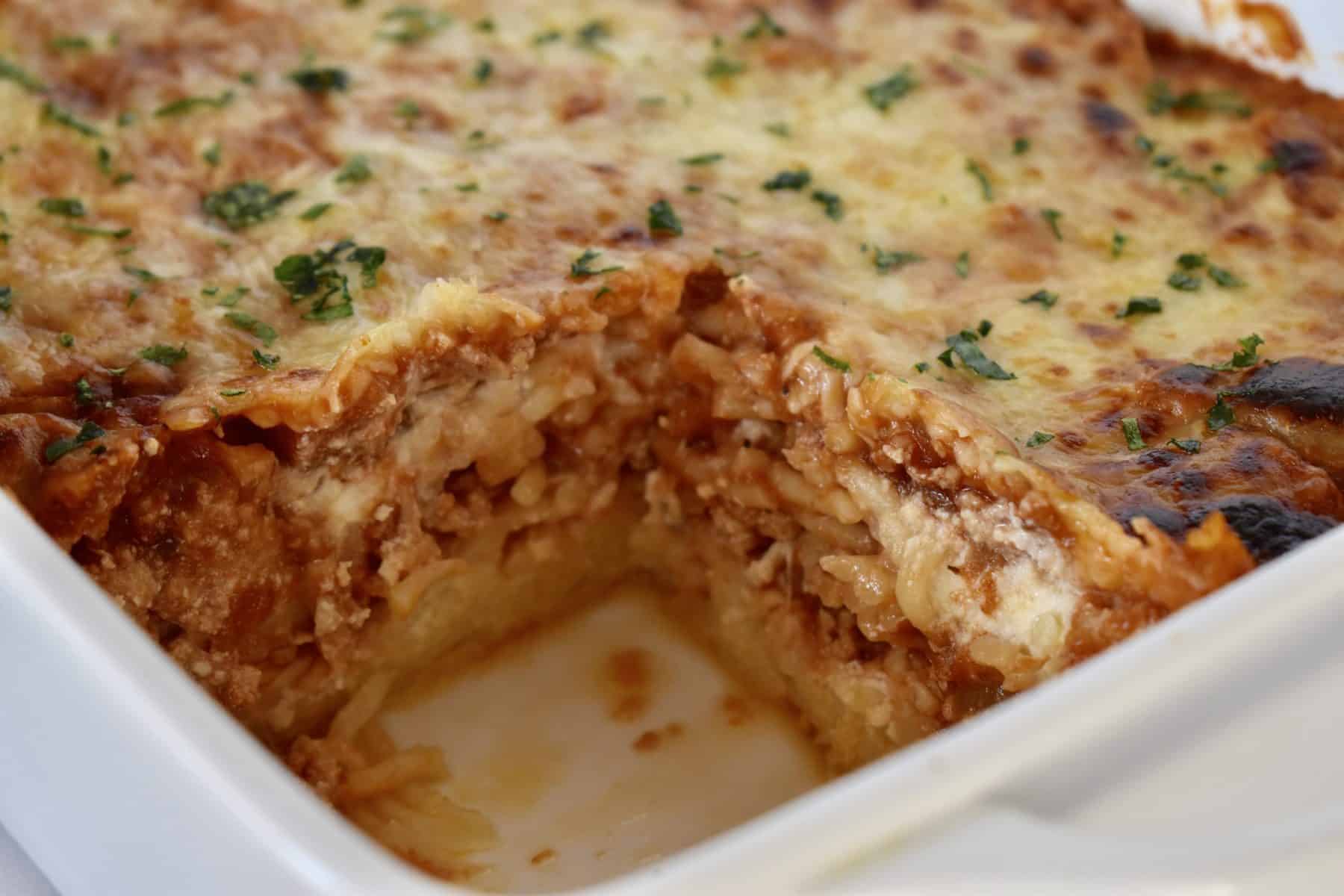 Baked Spaghetti with Ground Turkey in a white casserole dish. 